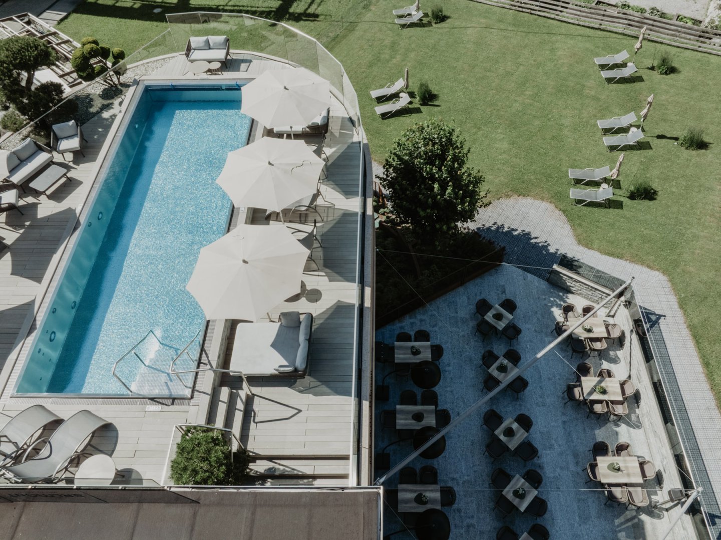 Rooftop Pool und darunter die Restaurantterrasse mit gedeckten Tischen