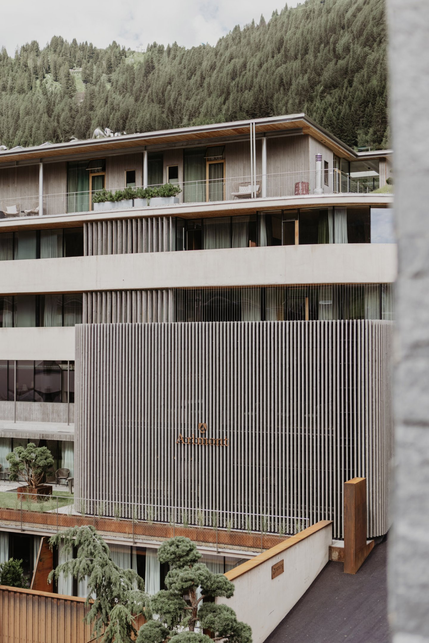 Façade with the lettering and green terraces, with the café terrace and chairs below