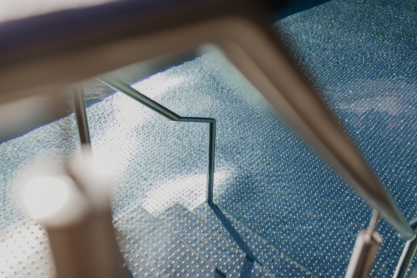 Glasgeländer und Wasseroberfläche des Rooftop Pools als Detailaufnahme