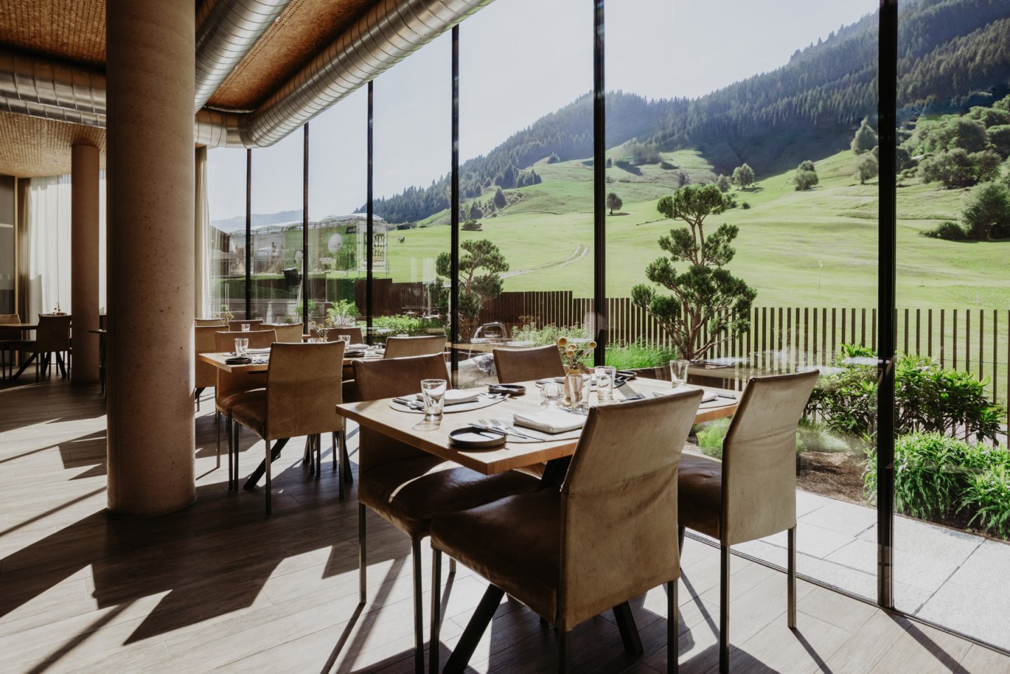Speisesaal mit gedeckten Tischen an der Fensterfront, Blick auf die grüne Golfwiese